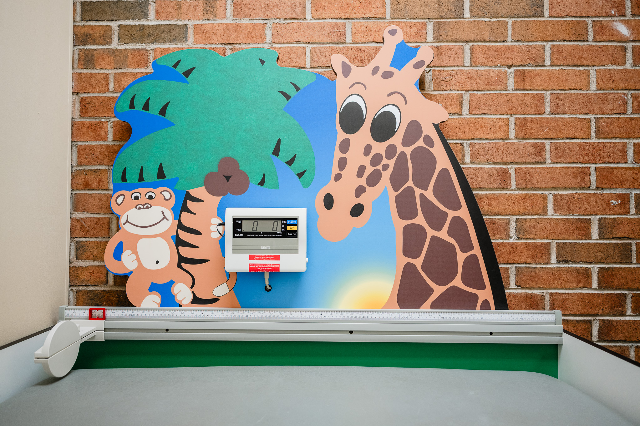 an art mural with a giraffe and monkey against a brick wall