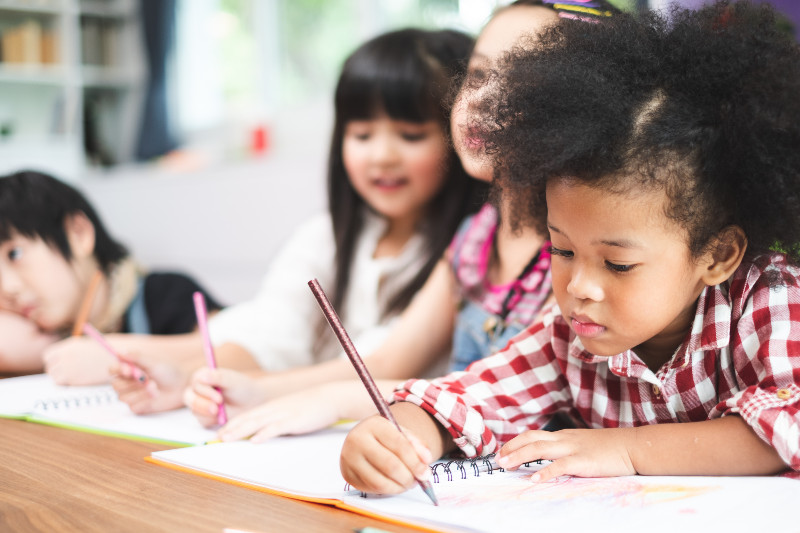 school children doing work on a table