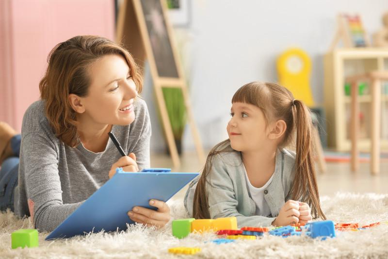 mother on floor with clipboard and her daughter next to her