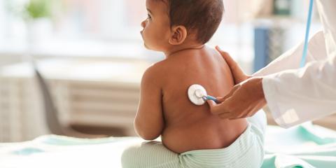 a pediatician listening to an infants heart